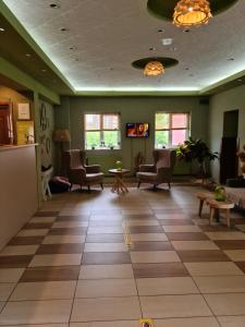 una sala de espera en un hospital con sillas y mesas en Hotel Olimp en Cluj-Napoca