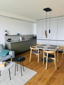 a kitchen and a living room with a table and chairs at Dakron Apartament in Puck