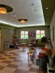 una sala d'attesa con divani, sedie e tavoli di Hotel Olimp a Cluj-Napoca