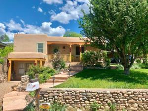 a house with a stone fence in front of it at 101 Llano Largo in Santa Fe
