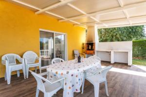 a dining room with a table and white chairs at Holiday's Paradise in Olhão