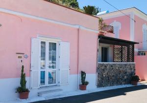a pink house with a white door and cactus at Pausa mare Ponza - Immobilevante in Ponza