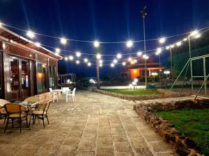 un patio con luci, tavoli e sedie di notte di Hotel Villa Elisabetta a Galatina