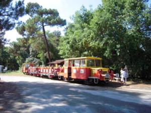 a small train with people riding on the tracks at Maison familiale spacieuse à Le Verdon-sur-Mer avec jardin 120 m² in Le Verdon-sur-Mer