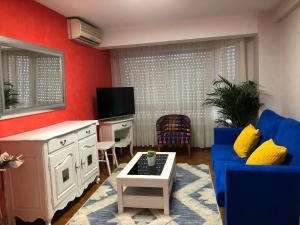 ein Wohnzimmer mit einem blauen Sofa und einem Fernseher in der Unterkunft APARTAMENTO MEXICO 6 (VIGO CENTRO) in Vigo