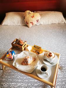 カターニアにあるBed & Breakfast Macallèのベッドの上にトレイ(食べ物、コーヒー付)