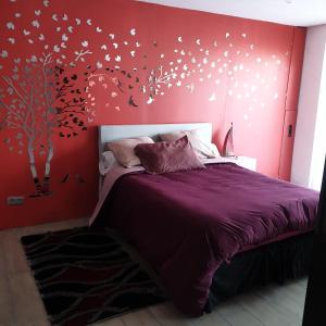 ein Schlafzimmer mit einem Bett und einem Baum mit Schmetterlingen in der Unterkunft Villa Rebecca in Villeparisis