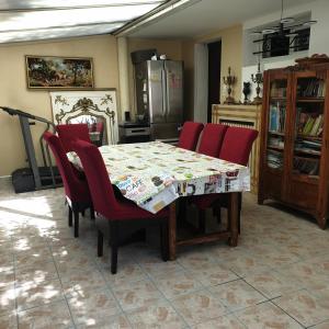 einen Esstisch mit roten Stühlen und eine Küche in der Unterkunft Villa Rebecca in Villeparisis