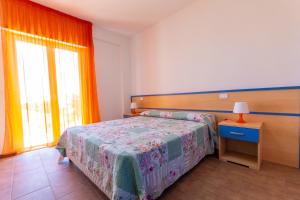 a bedroom with a bed and a window at Residence Palazzo Sayonara in Tortoreto Lido