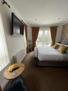 a bedroom with a bed and a table and a tv at Clanrye House Guest Accommodation in Newry
