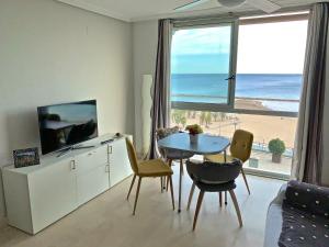 a living room with a table and a view of the beach at POSTIGUET BEACH in Alicante