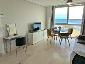 a living room with a dining table and a view of the beach at POSTIGUET BEACH in Alicante