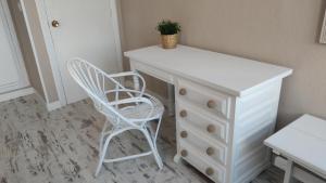 a white dresser and a chair in a room at Hotel Román in Naveces