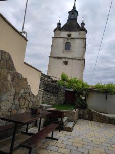 un edificio con una torre con una mesa y bancos en Holiday Home u Tetiany, en Kamianets-Podilskyi