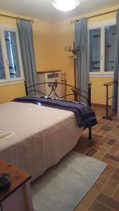 een slaapkamer met een groot bed en blauwe gordijnen bij Belle maison en Drôme provençale in Rousset-les-Vignes