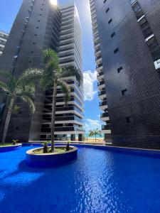 a palm tree in the middle of two tall buildings at Landscape Beira Mar Meireles in Fortaleza