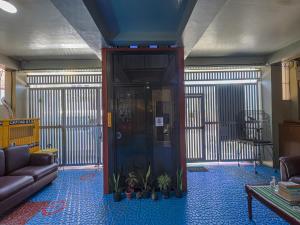 a lobby with a door with plants and a couch at Alicia Apartment in Manila