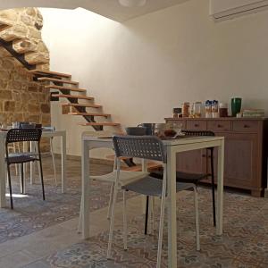 een kamer met tafels en stoelen en een trap bij Il Miglio in Più in Castel di Tusa