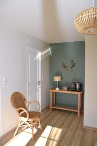 Zimmer mit einem Stuhl und einem Tisch in der Unterkunft Les Rougemonts Eucalyptus in Champguyon