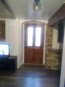 une porte avec une fenêtre et une télévision dans une pièce dans l'établissement Charmant petit studio proche départ GR20, à Calenzana