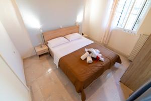 a bedroom with a bed with a teddy bear on it at THE HAPPINESS OF VANGELIS in Paralia Vrachou