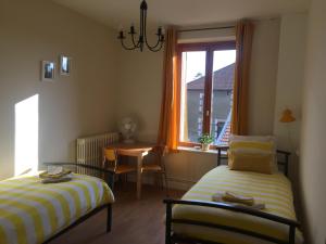 Zimmer mit 2 Betten, einem Tisch und einem Fenster in der Unterkunft 14-18 Meuse-Argonne in Montfaucon-dʼArgonne