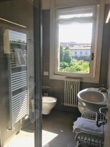 a bathroom with a sink and a toilet and a window at B&B San Benedetto in Bergamo
