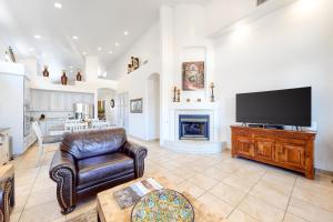 sala de estar con TV, sofá y chimenea en La Paloma Executive, en Tucson