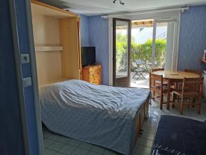 a bedroom with a bed and a table and a dining room at Studio Le Cécile in Le Croisic