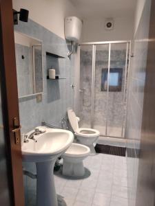 uma casa de banho com 2 WC, um lavatório e um chuveiro em Casa Lucia em Lavagna