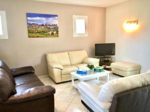 a living room with two couches and a tv at Résidence Alpha Centauri in Carcassonne