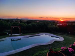Metókhion PatriotikónにあるVilla Traditional Estate Heated Pool & Garden, 5 bedroomsの夕日を背景にしたプール