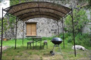 a grill and two chairs and a table and a building at Charmant Mas tout équipé en pleine nature catalane in Cases-de-Pène