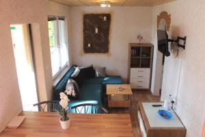 una sala de estar con un sofá y una mesa en Zum-Seehörnchen Haus Fuchs, en Tanna