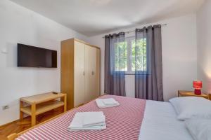 1 dormitorio con 1 cama, TV y ventana en Slavka en Mali Lošinj