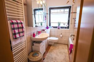 a bathroom with a sink and a toilet and a window at Erholungs-Apartment mit Balkon nahe Therme & Klinik in Bad Lippspringe +8 photos