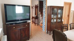 una sala de estar con TV de pantalla plana en un armario de madera en Keller Apartmanok, en Hajdúszoboszló