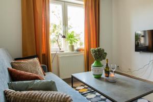 salon z kanapą, stołem i oknem w obiekcie Apartamenty Starówka w Olsztynie