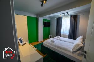 um quarto com uma cama com uma parede verde em Arca Sweet Apartment Ariniș em Gura Humorului