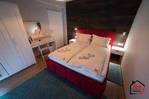 um quarto com uma cama com uma cabeceira vermelha e um espelho em Arca Sweet Apartment Ariniș em Gura Humorului
