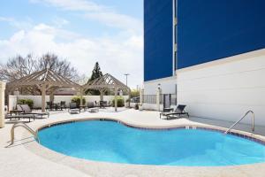 a pool at a hotel with chairs and a building at Holiday Inn Express & Suites - Atlanta - Tucker Northlake, an IHG Hotel in Tucker