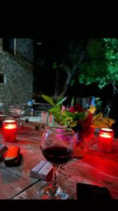 Traditional GuestHouse Permet في برميت: كأس من النبيذ تجلس على طاولة مع الشموع