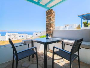 a table and chairs on a balcony with a view at Tinos Sea View Residence in Agios Sostis