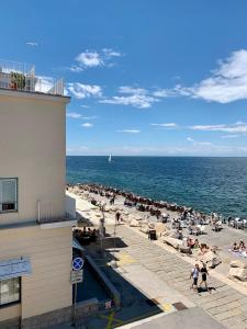 eine Menschenmenge am Strand in der Nähe des Ozeans in der Unterkunft Apartment Beachfront in Piran