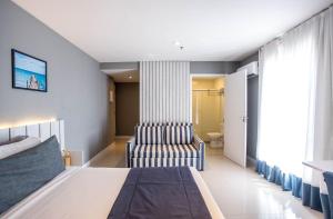 a bedroom with a bed and a chair at Flat 402 in Cabo Frio 700m from the beach in Cabo Frio