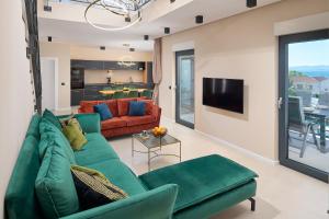 sala de estar con sofá verde y TV en Villa Allure, en Sutivan