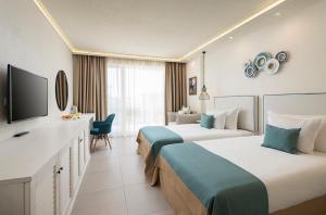 a hotel room with two beds and a flat screen tv at Siena Premium Retreat - Free parking in Lozenets