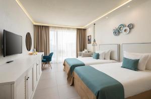 a hotel room with two beds and a flat screen tv at Siena Premium Retreat in Lozenets