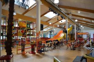 a restaurant with a playground and tables and chairs at PENTHOUSE Appartement Bergliebe Sankt Englmar in Sankt Englmar