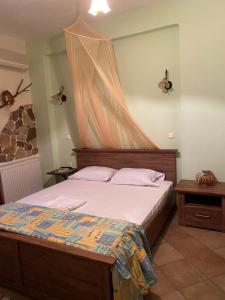 a bedroom with a bed with a mosquito net on it at Guesthouse Kerkinitis in Lithótopos